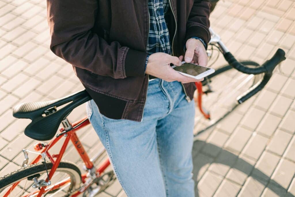 Photo d'un homme assis sur son vélo avec un téléphone à la main