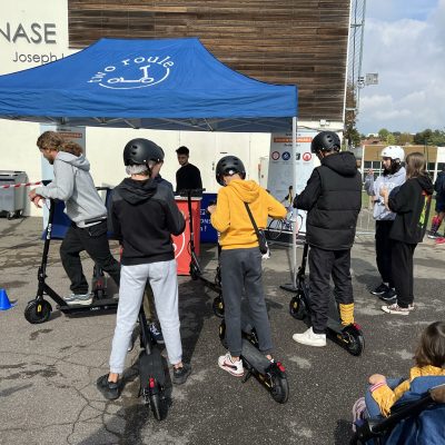 Photo de jeunes à Garches sous le stand Two Roule qui essayent la trottinette électrique